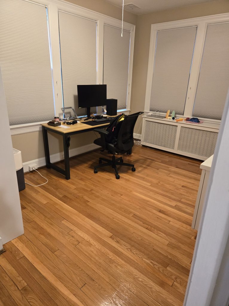Home office with desk and clean wood floor